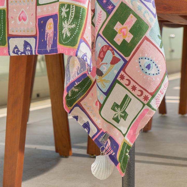 Colorful celestial dreams print tablecloth with geometric patterns draped over a wooden chair.