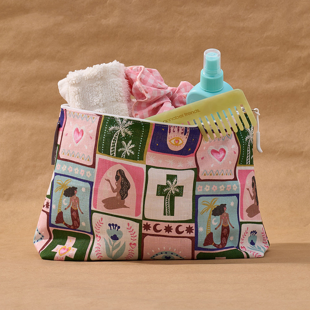 Patchwork-patterned celestial dreams cosmetic bag with toiletries on a brown background