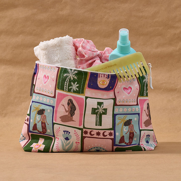 Patchwork-patterned celestial dreams cosmetic bag with toiletries on a brown background