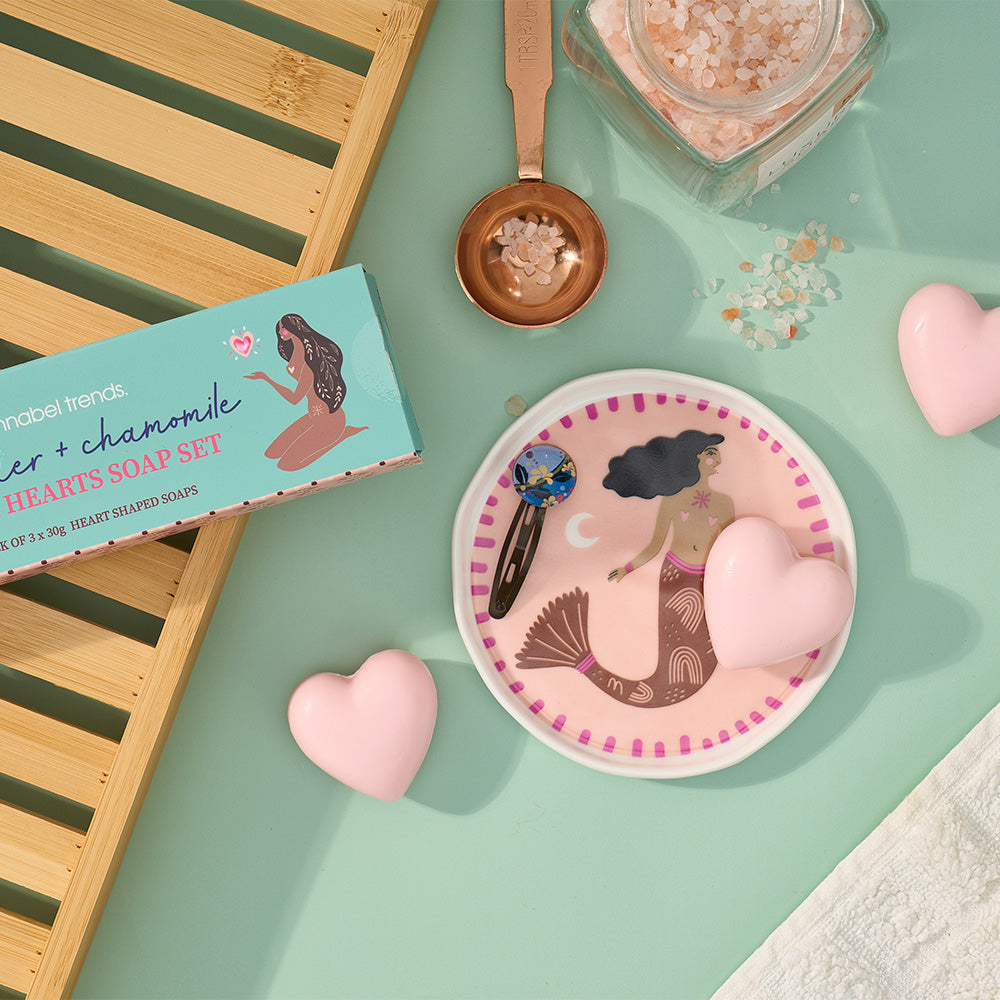 Mermaid-themed soap set with heart-shaped soaps, a plate, and measuring spoon on a green surface.