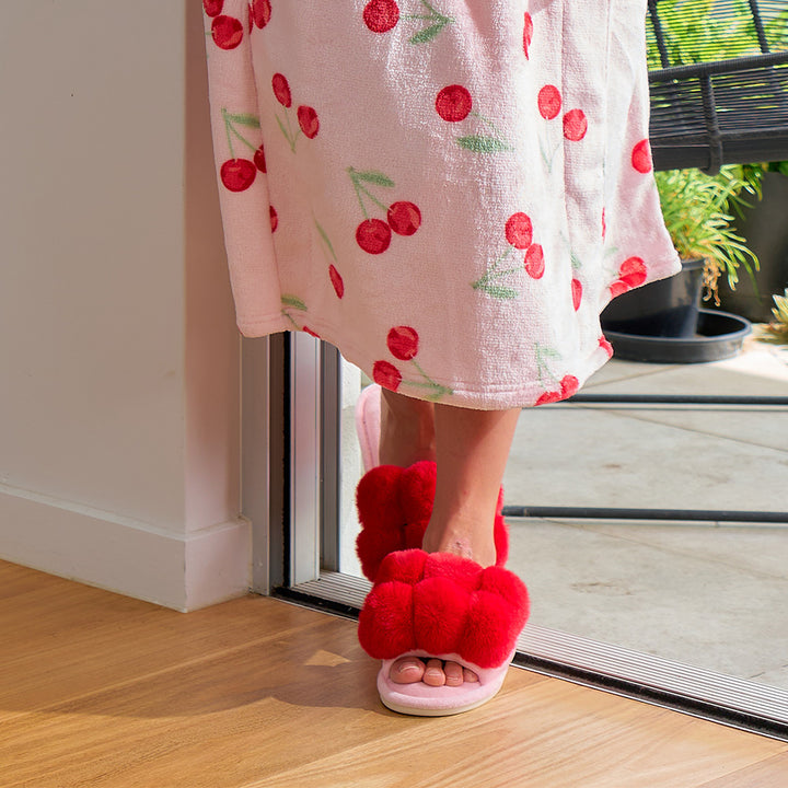 lady wearing a bath robe with cherries on it and cherry red and pink slippers on