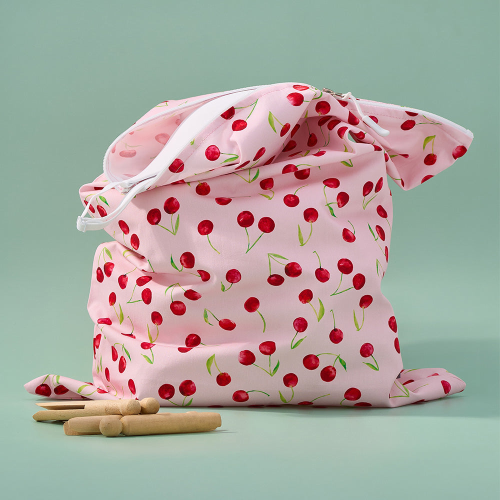 Pink laundry bag with cherry pattern on a light green background