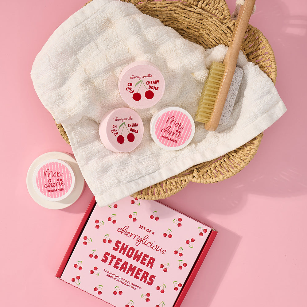 Set of cherry-themed shower steamers with packaging on a pink background
