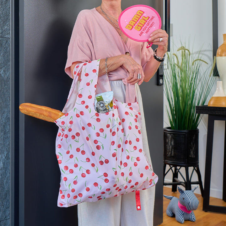person holding cherry designed shopping tote