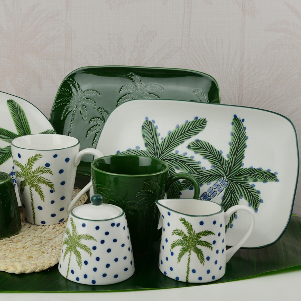 Set of ceramic tableware with palm tree design on a white background