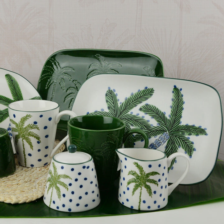 Set of ceramic tableware with palm tree design on a white background