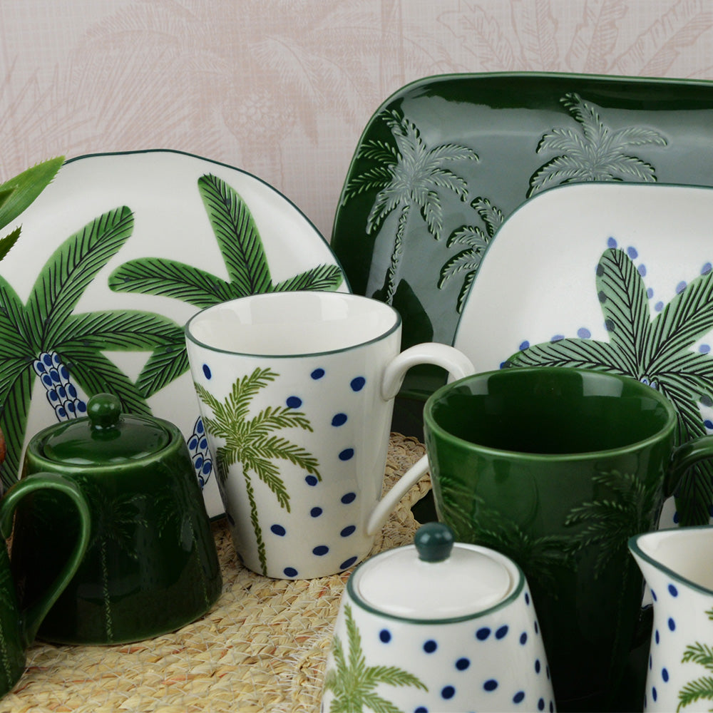 Set of ceramic tableware with palm tree design on a textured surface