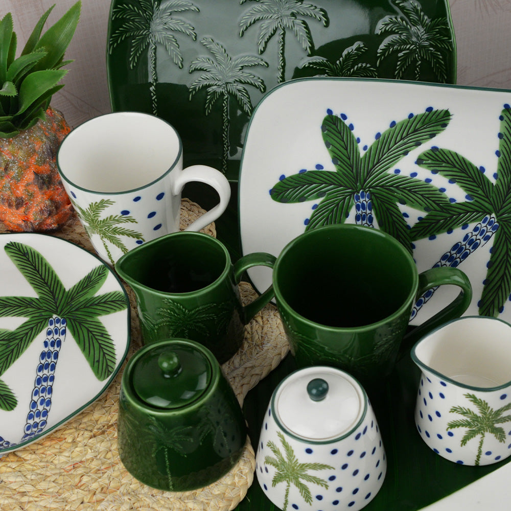 Set of ceramic items with palm tree design on a decorative surface