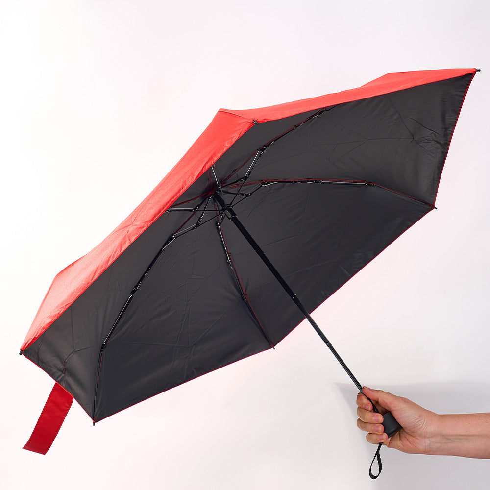Black and red umbrella held by a hand on a white background