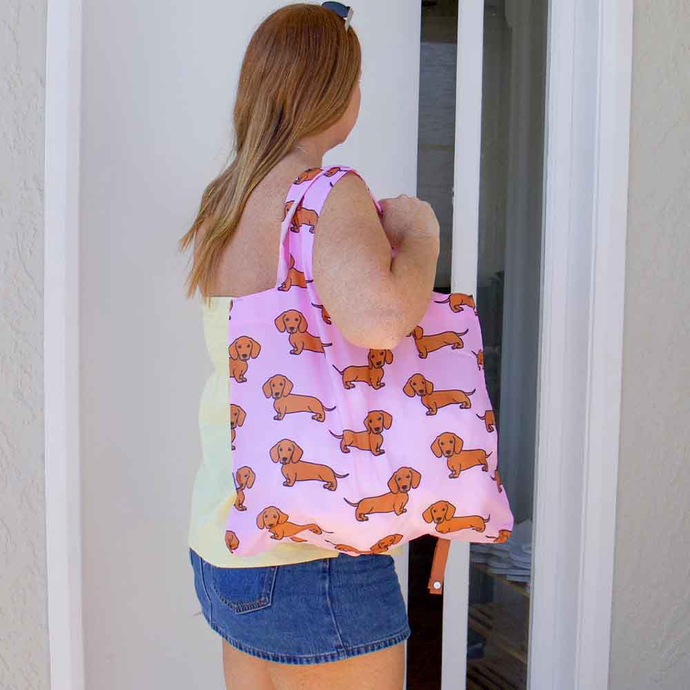 Woman carrying a shopping tote with dachshund pattern