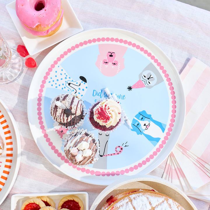 Cake Serving plate with dog cartoon designs of ice cream cones surrounded by pastries on a light pink background.