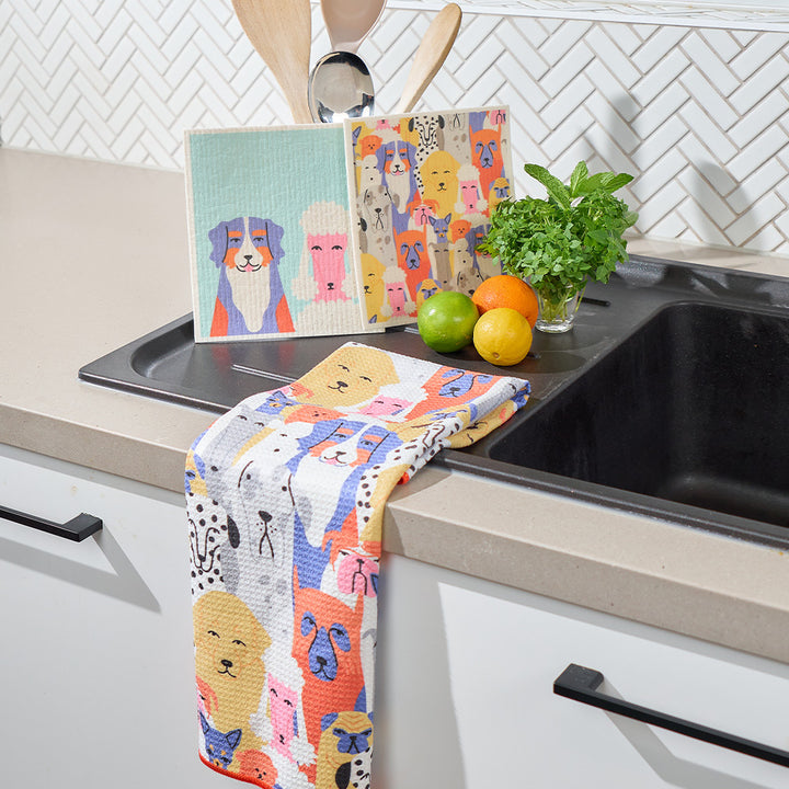 Colorful kitchen towel with dog designs hanging over a sink