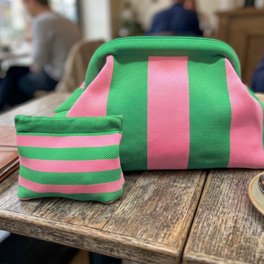Green and pink striped pouches on a wooden table with blurred background