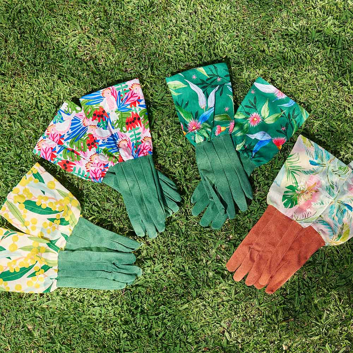 Set of gardening gloves with floral and green patterns on grass