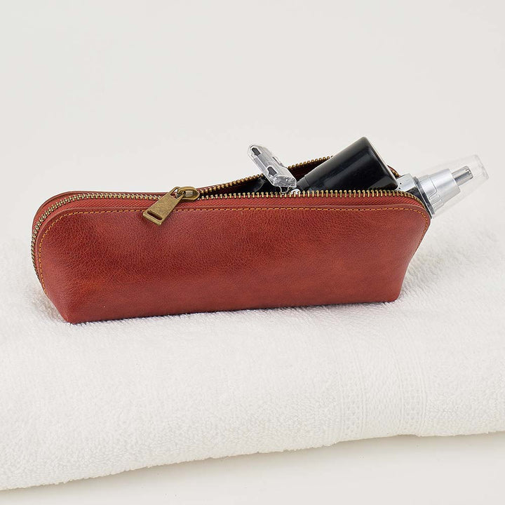 Brown leather pouch with gold zipper on a white background