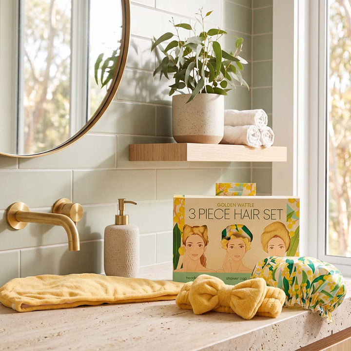 Bathroom counter with a 3-piece hair set packaging, yellow hair accessories, and a plant.