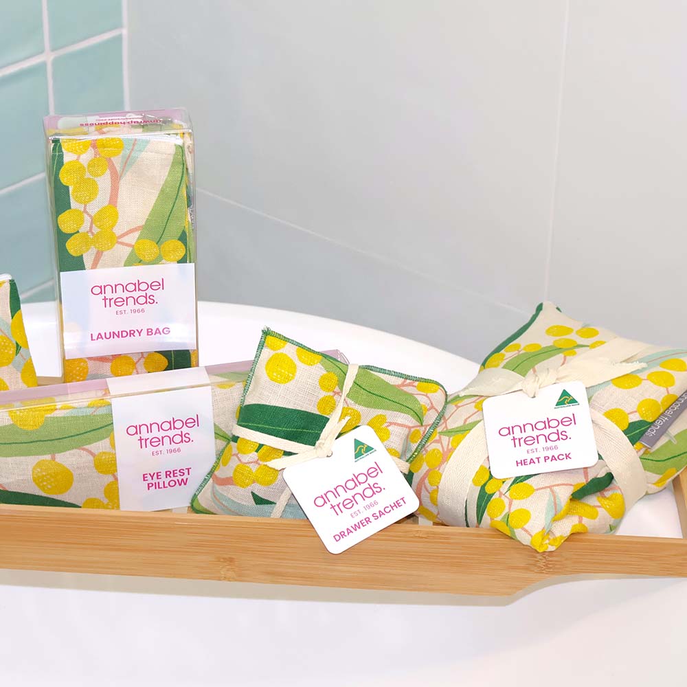 Collection of Annabel Trends products including a laundry bag, eye rest pillow, and heat pack on a tray.