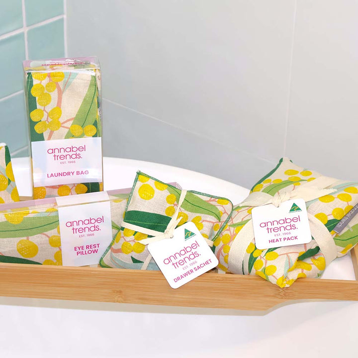 Collection of Annabel Trends products including a laundry bag, eye rest pillow, and heat pack on a tray.