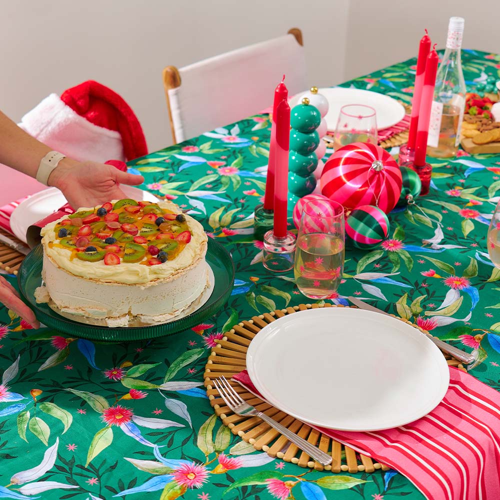 Decorative table setting with a cake, plates, and colorful tablecloth.