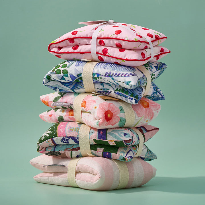 Stack of colourful folded heat pillows on a light green background
