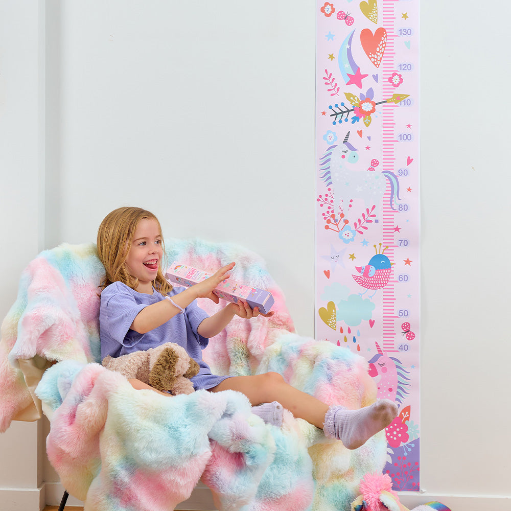Child sitting on a colorful chair with a growth chart in the background