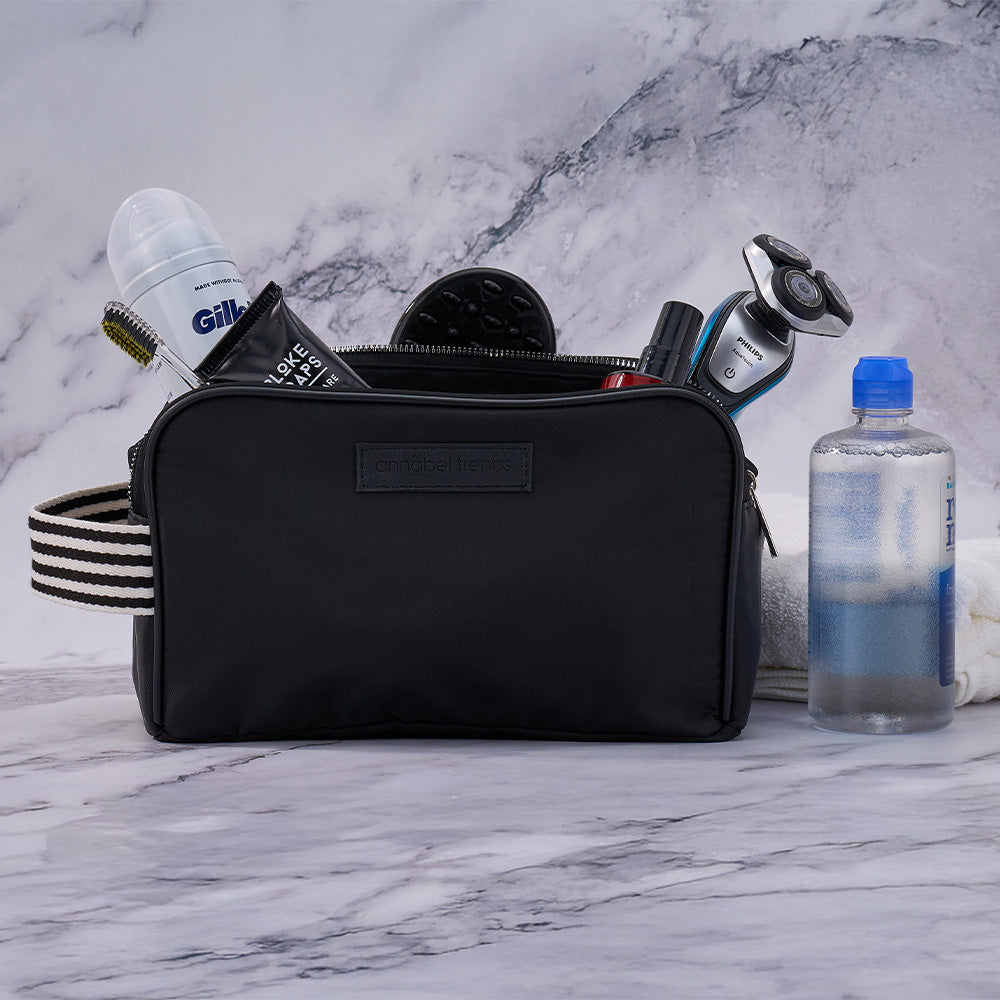 Black AT Hype toiletry bag with grooming products on a marble surface