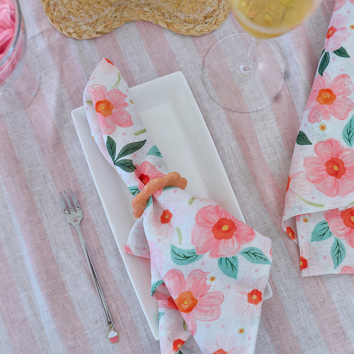 Floral-patterned napkin with a fork on a striped tablecloth