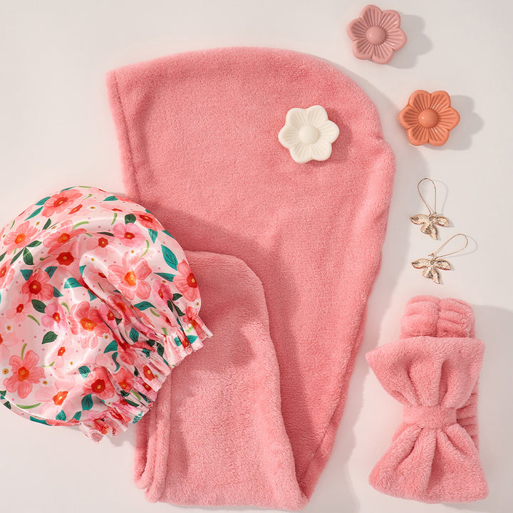 Pink hair towel set with floral bonnet and hair accessories on a light background