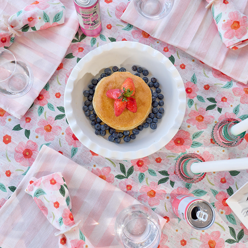 Pancakes with blueberries and strawberries on a floral tablecloth