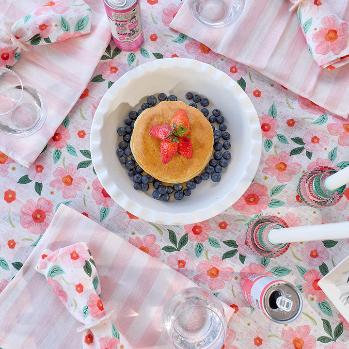 Pancakes with blueberries and strawberries on a floral tablecloth