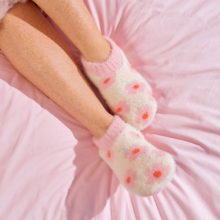 cream fuzzy booties with pink floral print worn by person