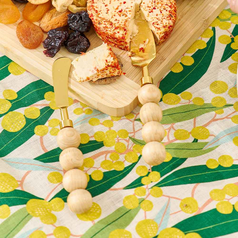 Cheeseboard with assorted cheeses and dried fruits on a decorative tablecloth.