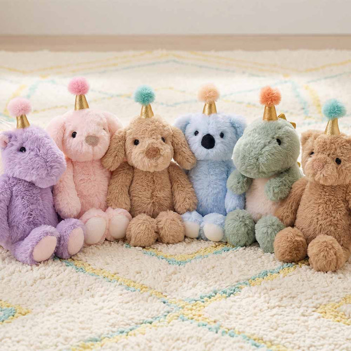 Colorful stuffed animals with party hats on a patterned rug