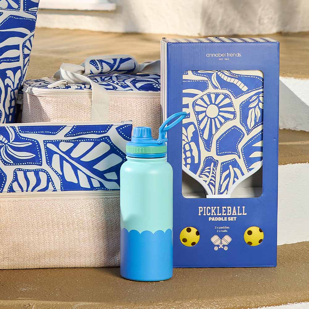 Blue and green water bottle with pickleball paddle set packaging on a wooden surface.