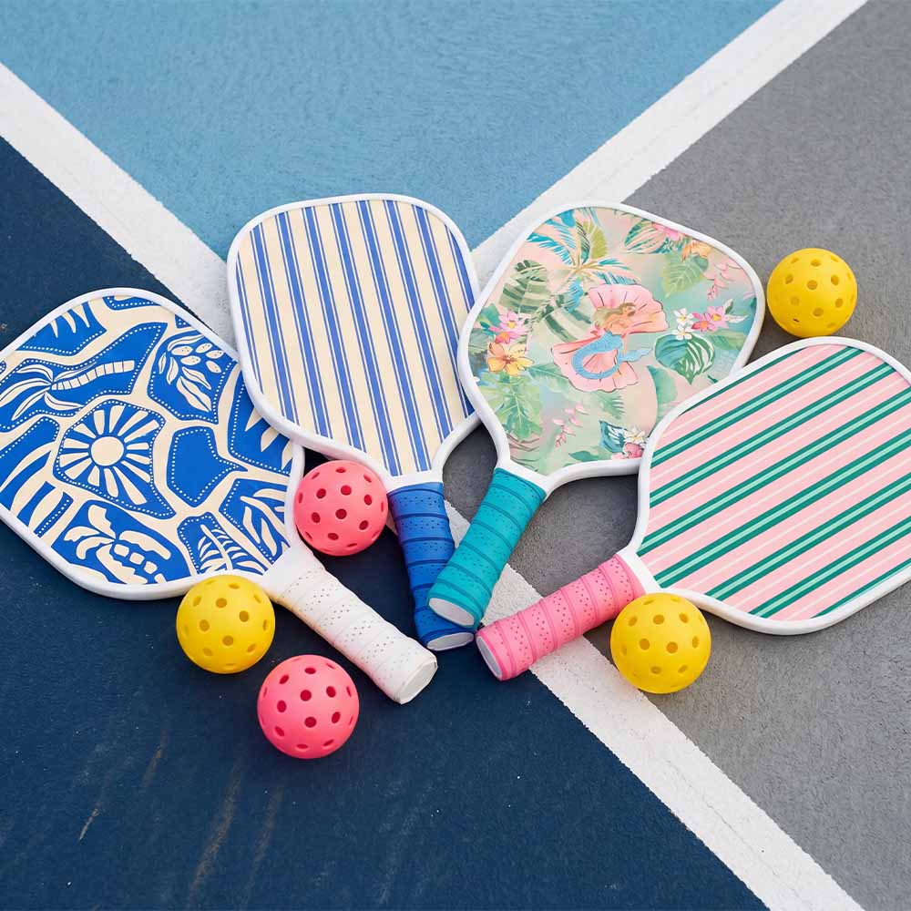 Colorful paddle ball rackets and balls on a blue and gray surface
