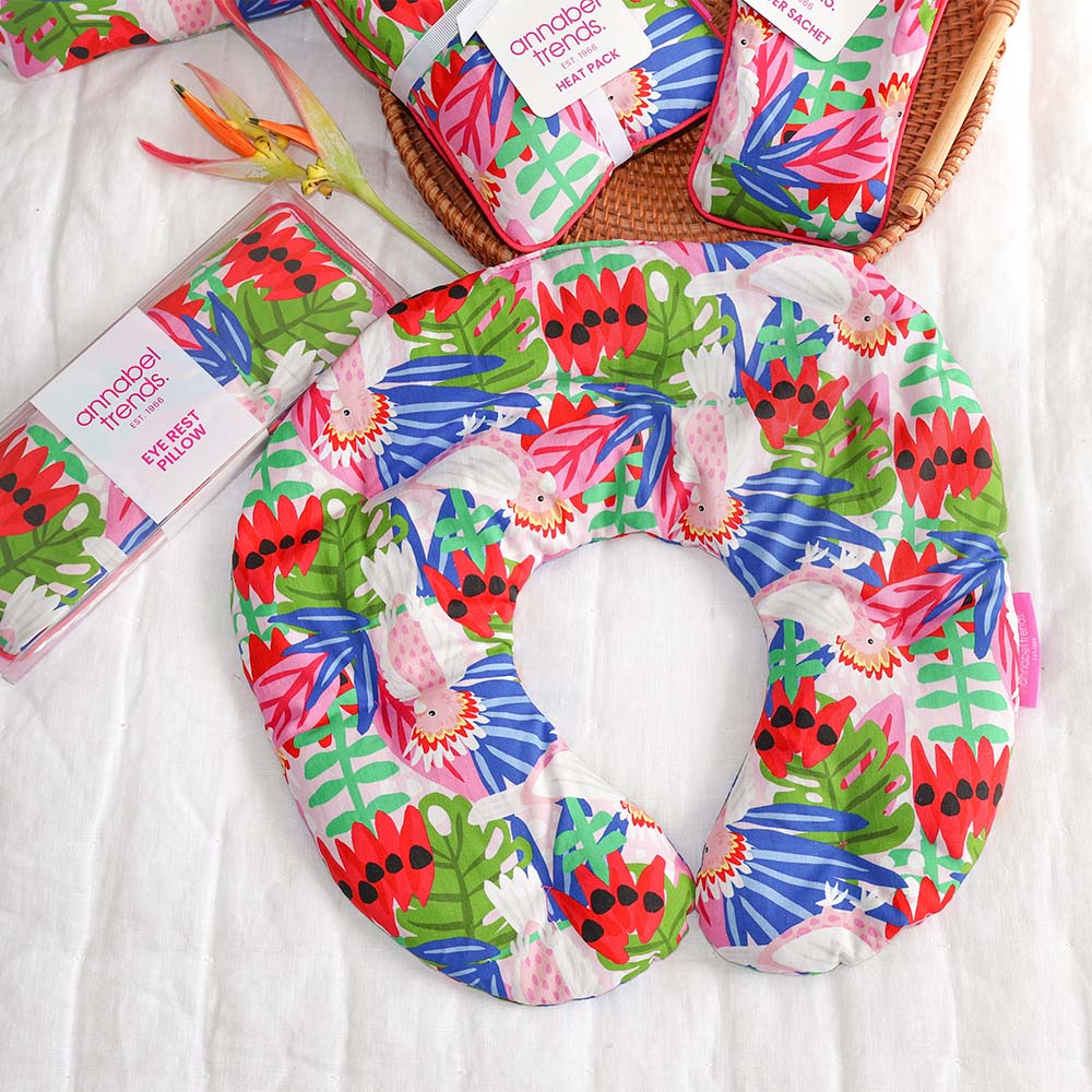 Colorful tropical patterned neck pillow with packaging on a white background