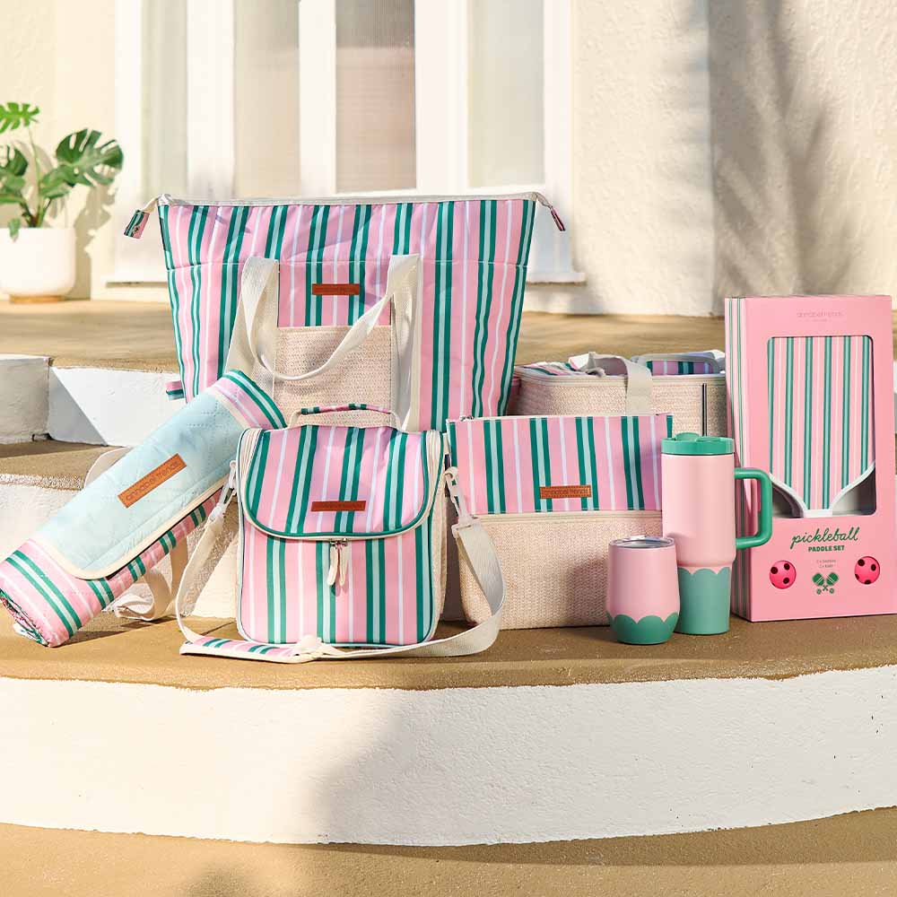 Collection of pink and green striped bags and accessories on a wooden surface.