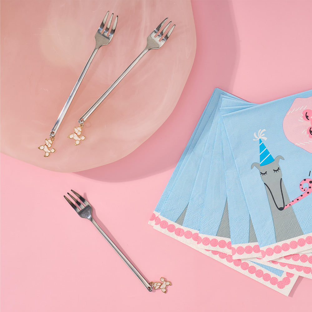 Decorative forks and themed napkins on a pink background