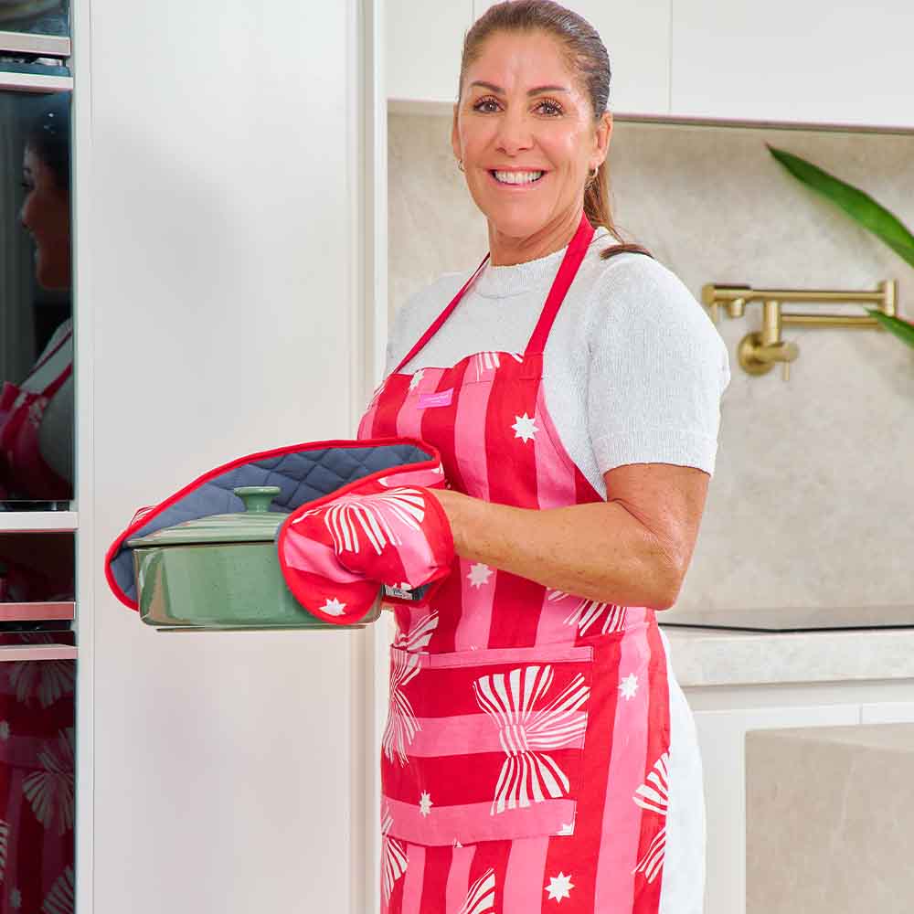 red and pink striped apron with white printed bows worn by a lady in the kitchen