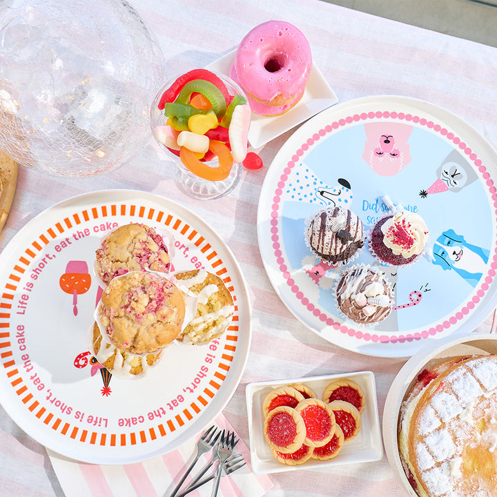 Assorted pastries and plates with illustrations on a table setting.