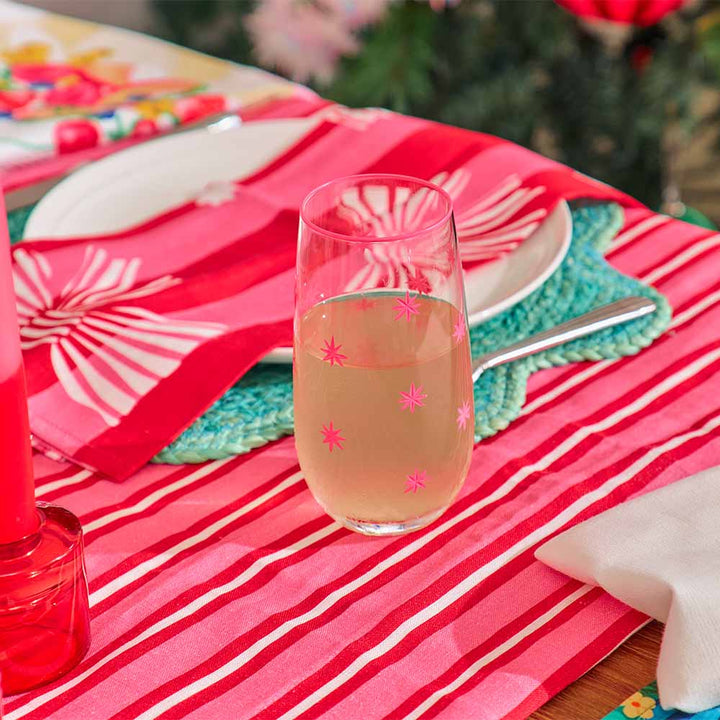 Glass of champagne on a colorful tablecloth with floral napkins