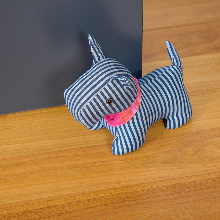Striped dog-shaped door stopper on a wooden surface
