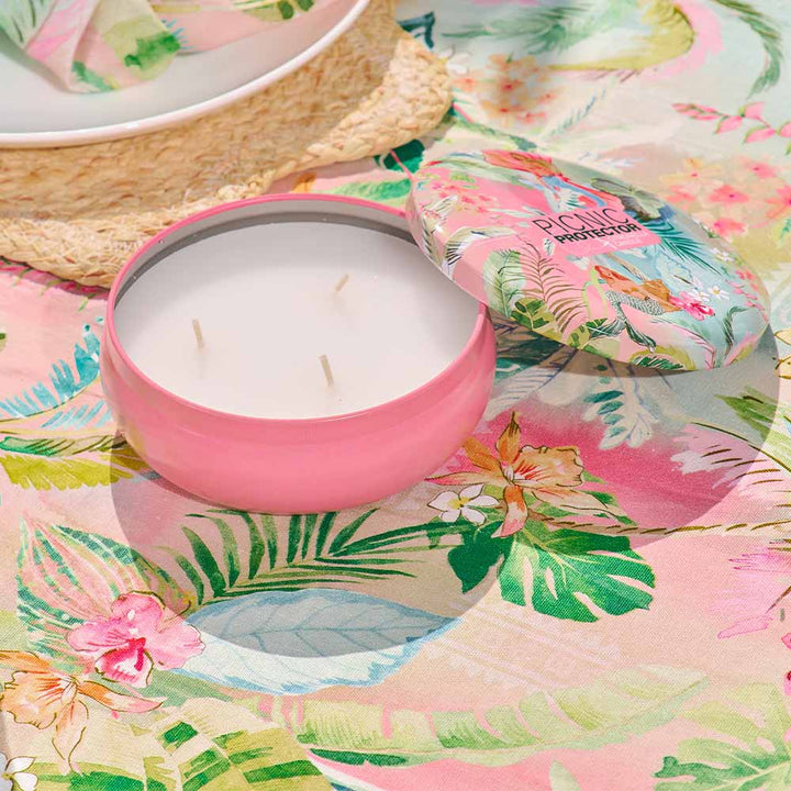 Pink candle in a floral-patterned lid on a colorful floral background