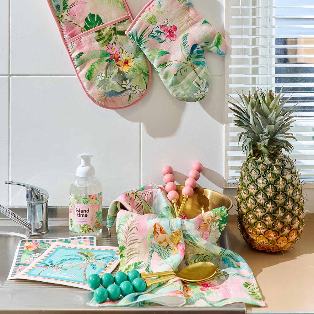 Kitchen counter with floral towels, pineapple, and colorful decor