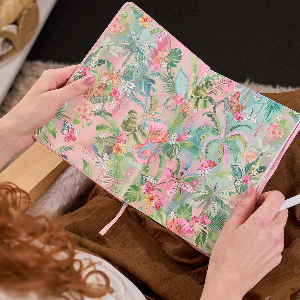 Floral patterned notebook held by a person with a blurred background