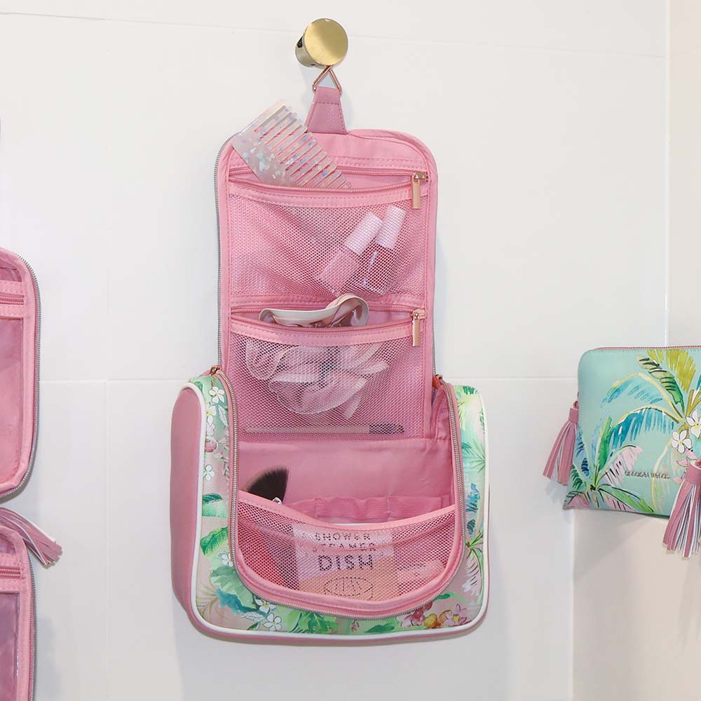 Pink hanging toiletry bag with tropical design on a white background
