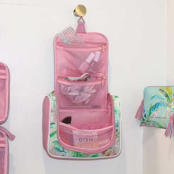 Pink hanging toiletry bag with tropical design on a white background