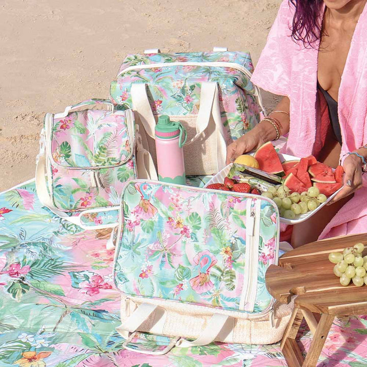 Floral-patterned picnic set with food on a beach
