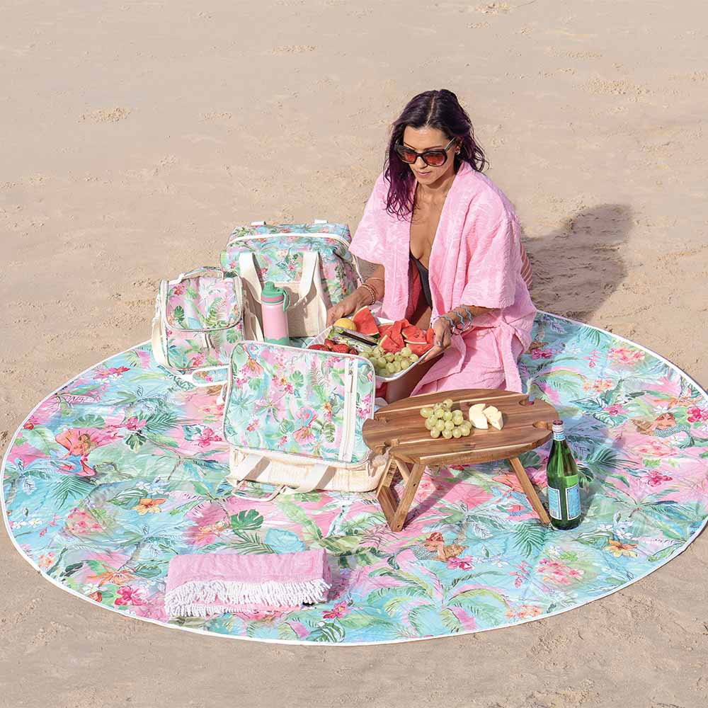 Woman on a floral picnic blanket with picnic setup