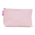 Pink waffle-textured cosmetic bag with a white zipper on a white background